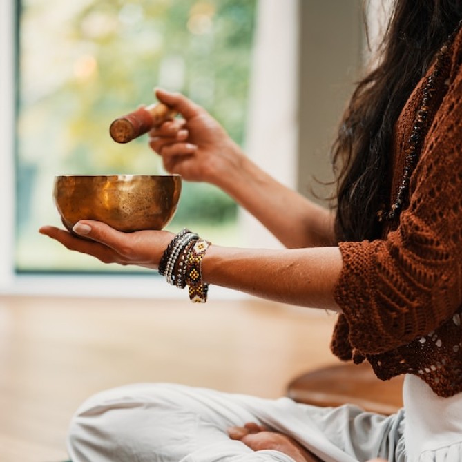 A singing bowl held in a quiet space for reflection.
